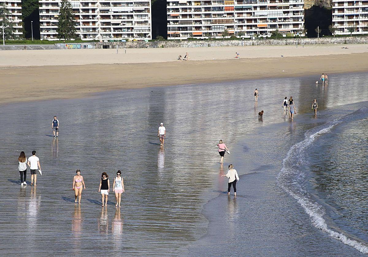 Un grupo de personas pasea por la orilla de la playa de Hondarribia.