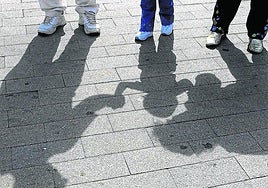 Un niño pasea de la mano de sus padres.