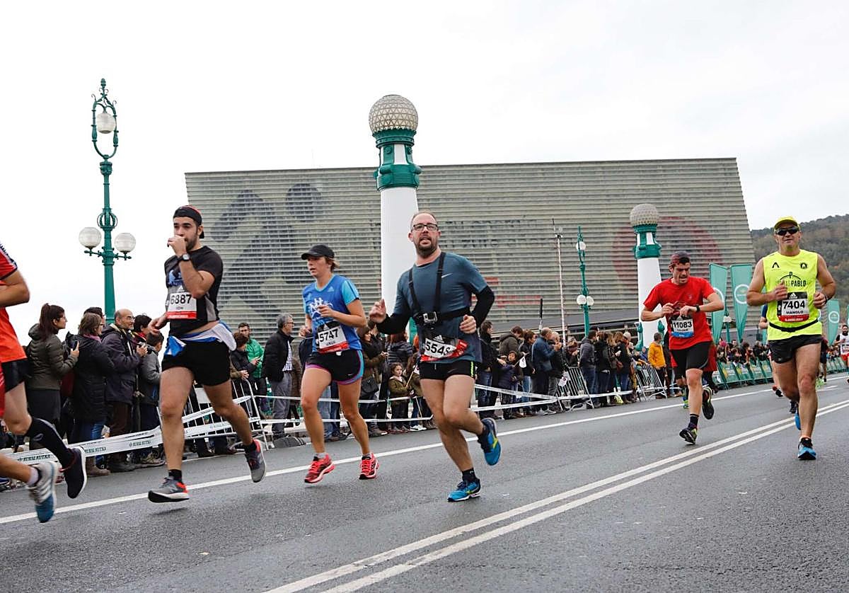 Los corredores de la behobia a su paso por el puente Kursaal bajo el cielo cubierto.