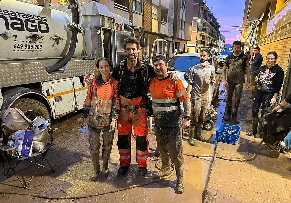 Nagore y Alberto junto a un bombero y el camión de su empresa de desatascos en Paiporta.