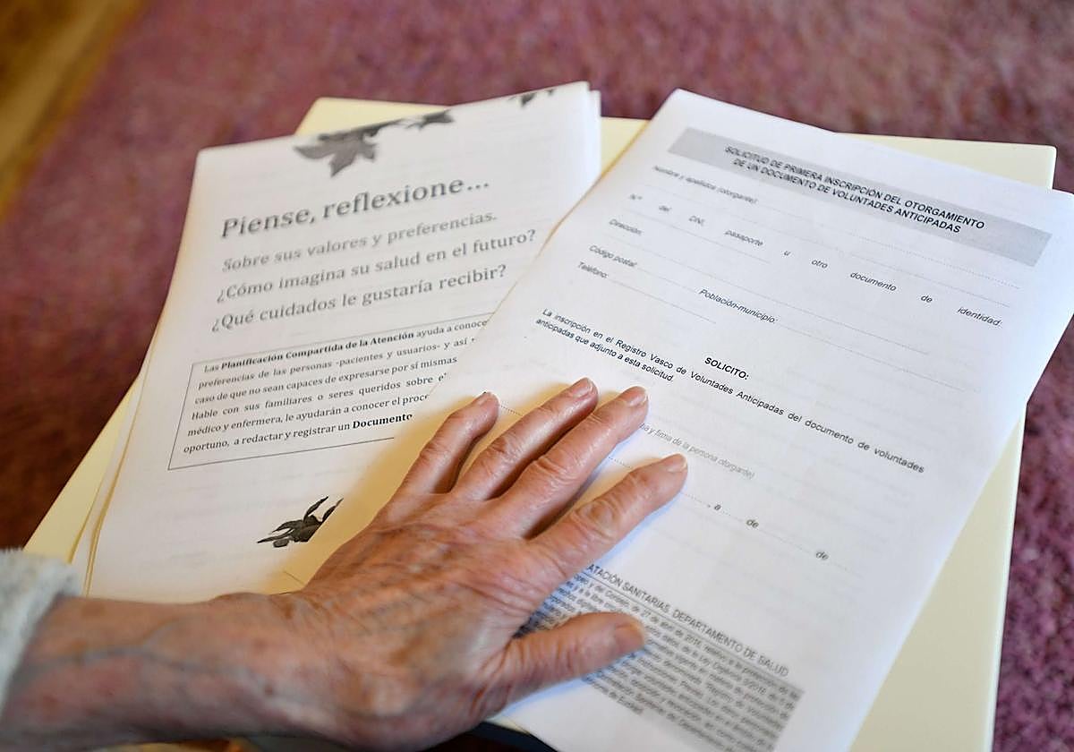 Una persona mayor sujeta documentos de voluntades no deseadas.