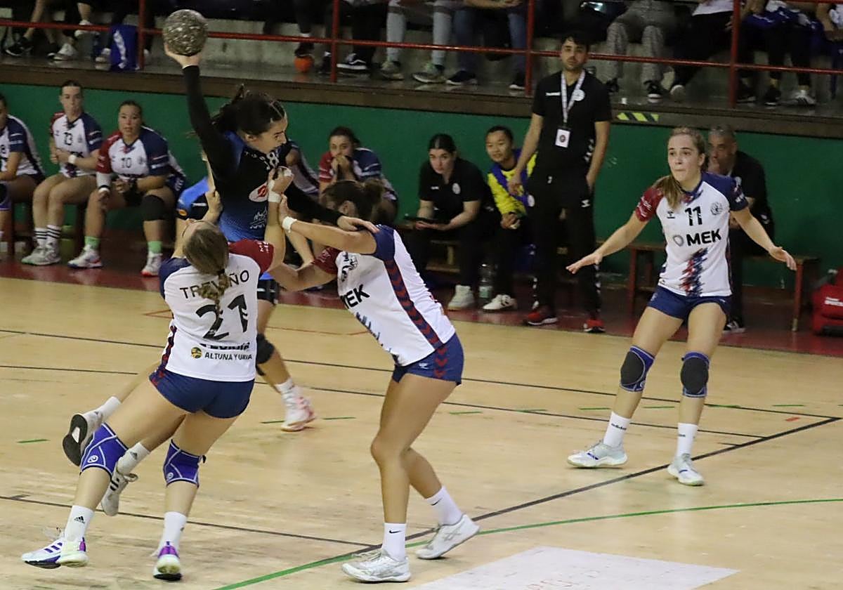 Dos jugadoras del Mek Eibar femenino defienden el lanzamiento de una rival.