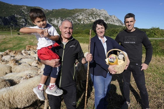 La familia de La Leze junto a su rebaño y sus quesos en manos de Eli Gorrotxategi.