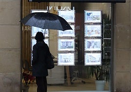 Una mujer observa la oferta en una agencia inmobiliaria.