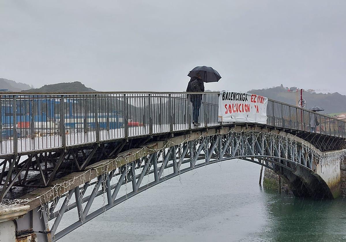 Cartel de apoyo a los trabajadores de Astilleros Balenciaga en el puente de Moilaberri, con Balenciaga al fondo.