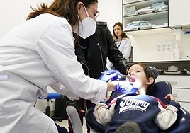 Una dentista revisa la boca a un niño menor de 6 años.