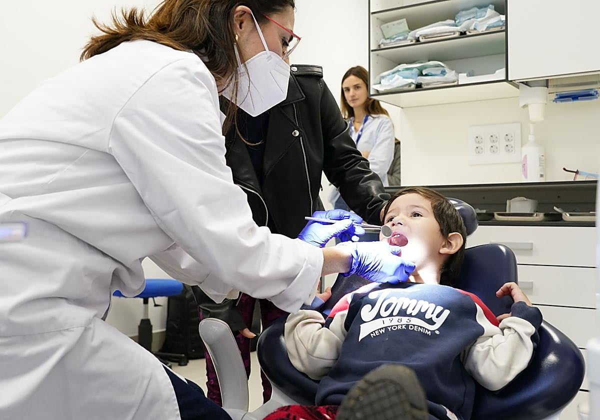 Una dentista revisa la boca a un niño menor de 6 años.