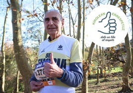 Fernando Gajate, con la camiseta y el dorsal con los que disputó la última Behobia-SS, hace el gesto con el dedo de apoyo a Kirolean Errespetuz en Donostia.