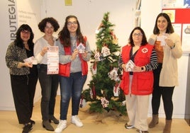 Representantes municipales y de Cruz Roja junto al árbol de la biblioteca.