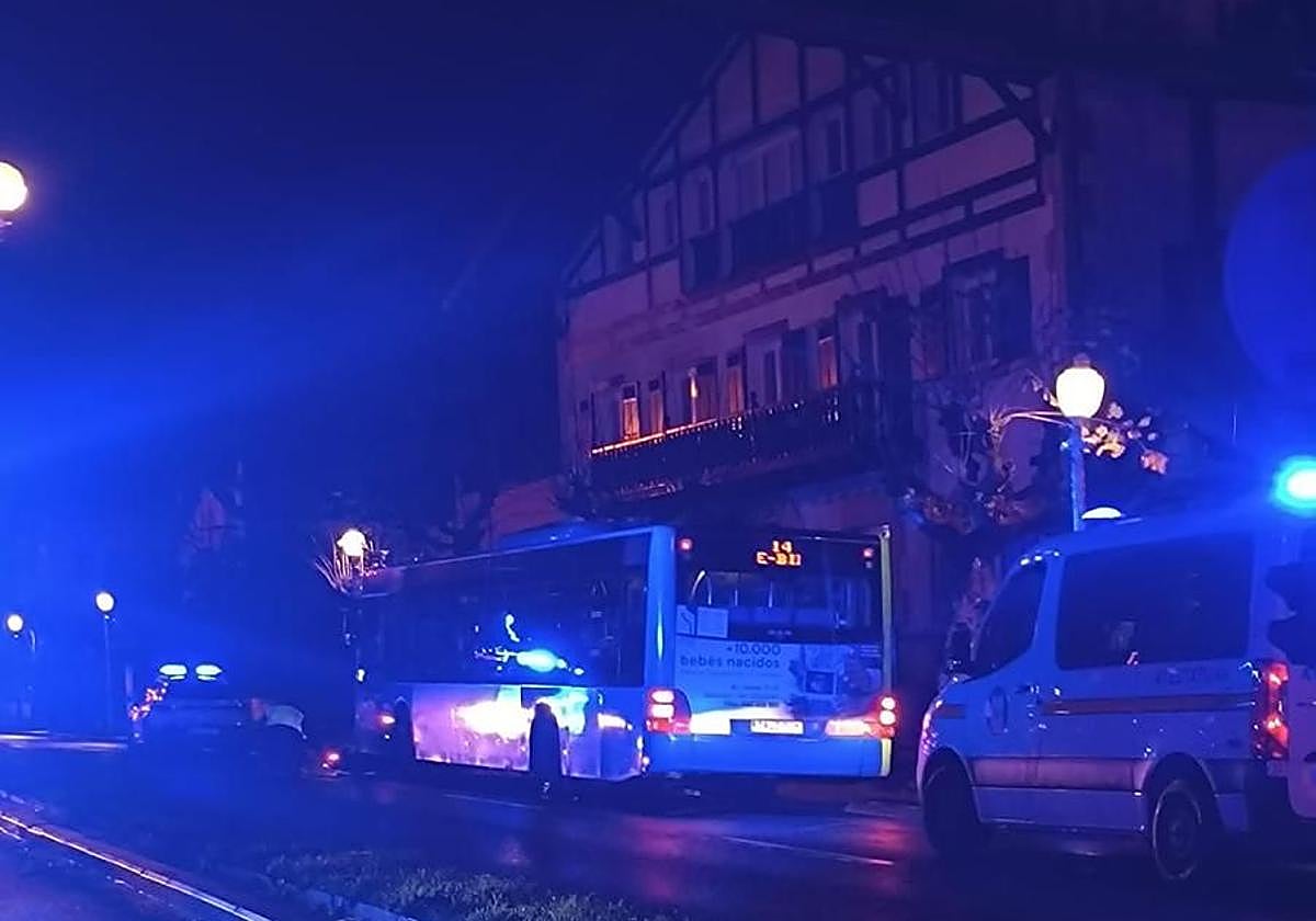 Agentes de la Ertzaintza y la Guardia Municipal tratan de sacar la moto encajada bajo el autobús de la línea 14 de Dbus, este sábado en la avenida de Navarra de Gros.