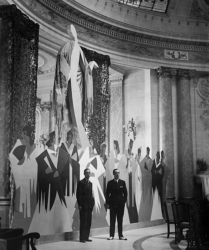 Imagen secundaria 2 - Arriba, Landi, Valverde, Cabanas, Garrido y Bueno, entre otros, en una fiesta de disfraces en el Casino. En el medio, el periodista Rafael Sánchez Mazas, asomado al púlpito desde el que se daban los discursos en GU. Debajo, Eduardo Lagarde y Jesús Olasagasti, delante de los murales realizados por el primero de ellos en el Gran Casino.