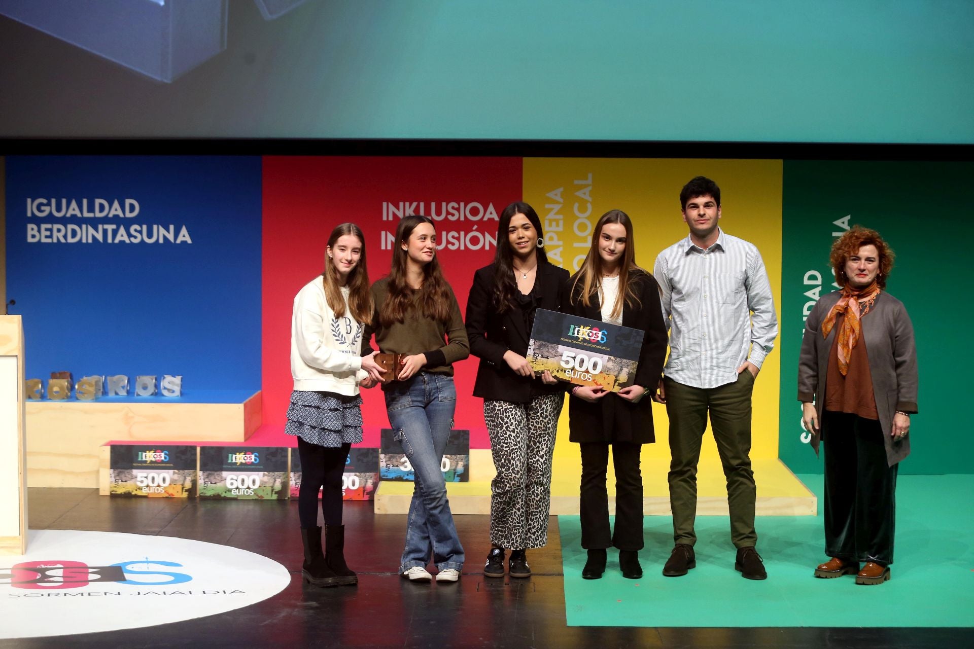 Izaro Blanco, Izaro Aliende, Nahia Fernández y Lexuri Artetxe / Inklusibitatea. Las ganadoras de EKOS Populares en la modalidad Gráfico reciben el premio de manos de Rosa Lavín, presidente de Konfekoop, e Iñigo Soto, técnico de Emprendimiento y Jurídico de ASLE.