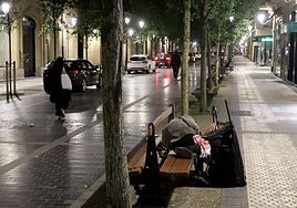 Una persona sin hogar duerme en un banco en Donostia.