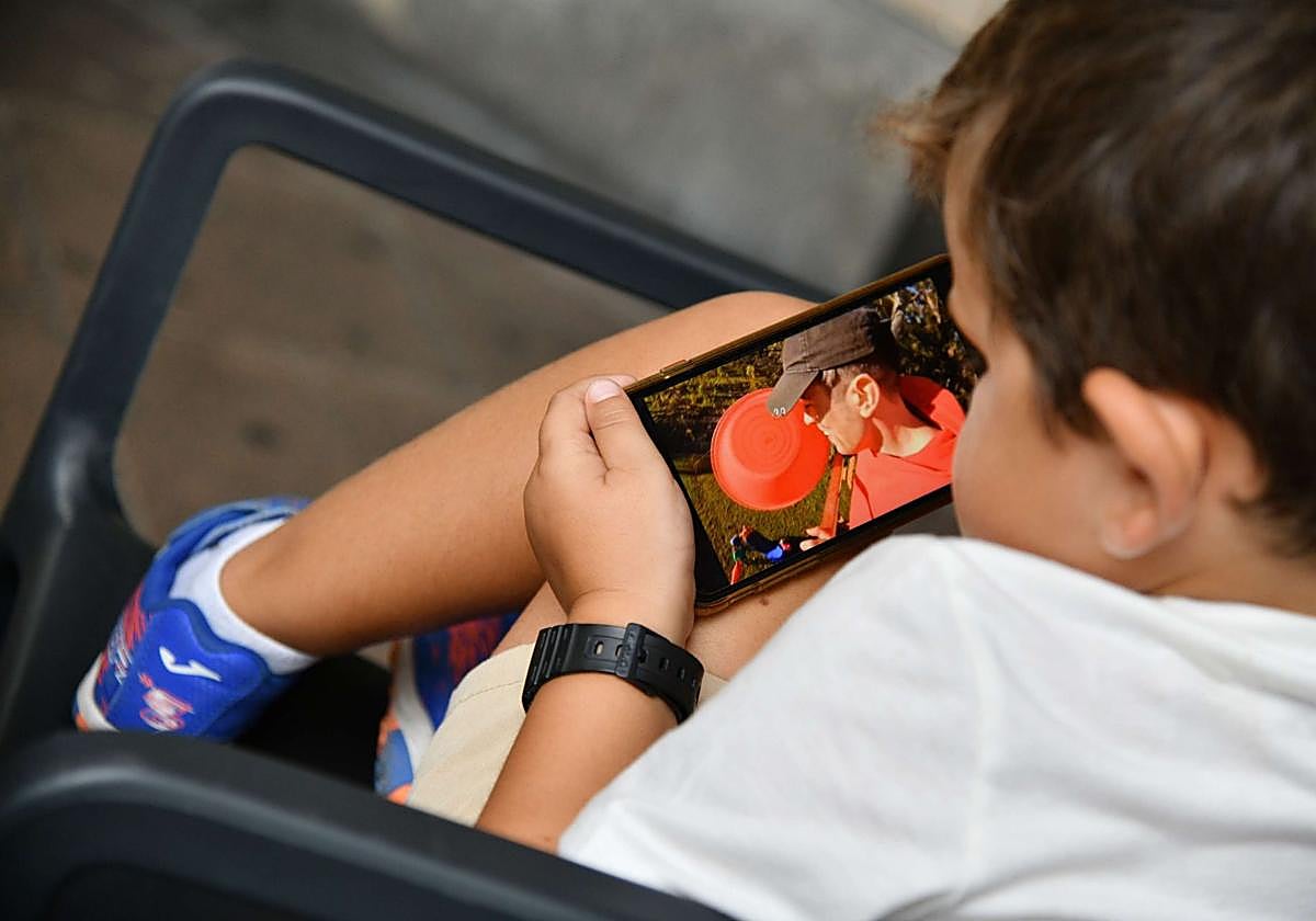 Un niño pequeño hace uso de un teléfono móvil.