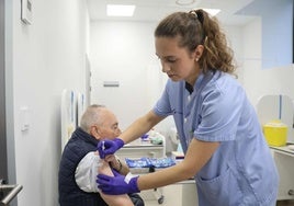 Una enfermera inocula la vacuna contra la gripe a un hombre.