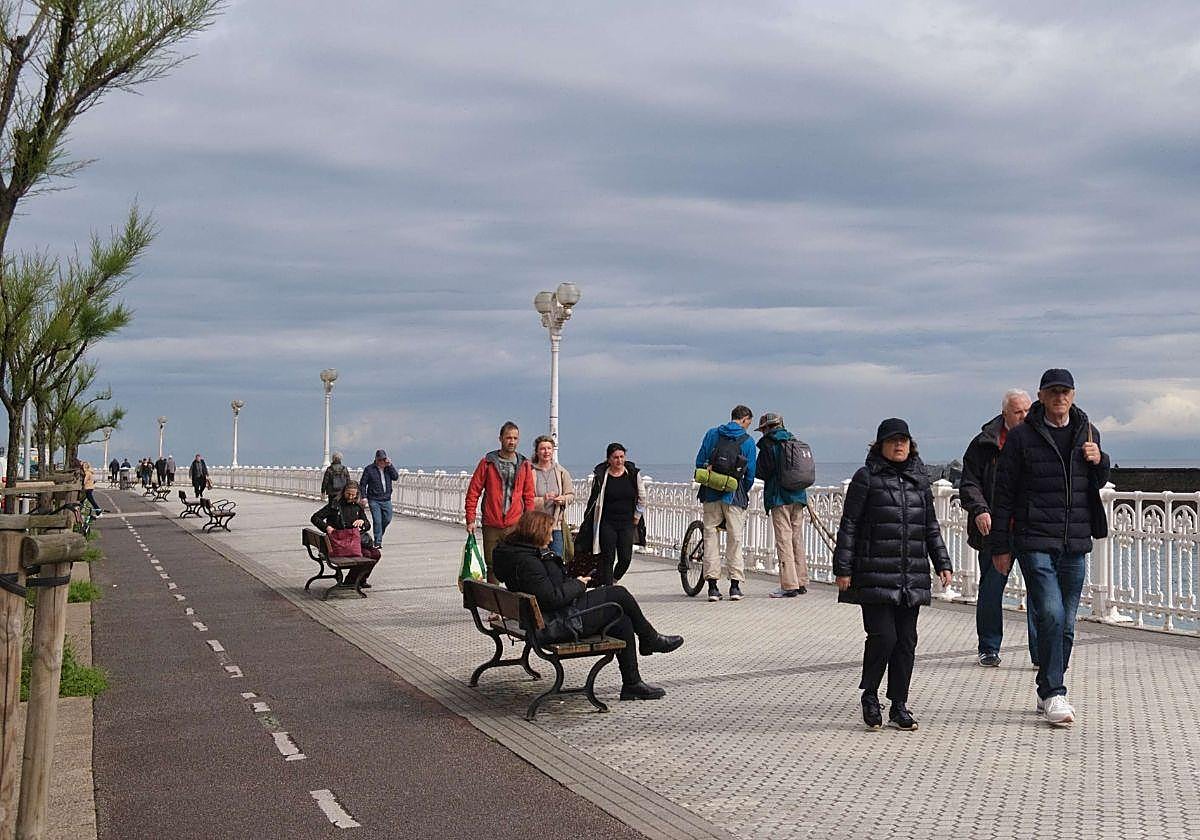 Un grupo de personas caminan por el Paseo Nuevo de San Sebastián.