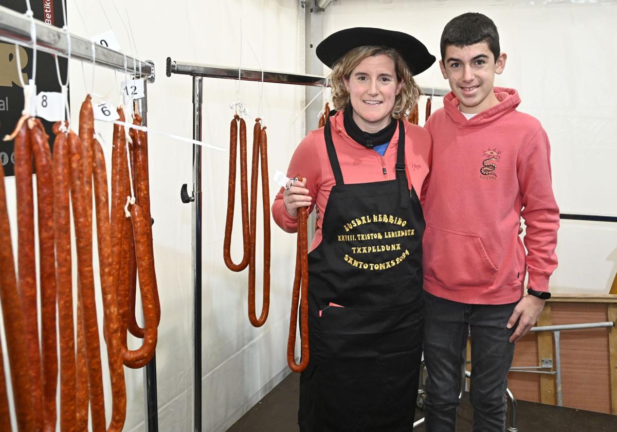 Ainhoa Loidi, con su txapela de ganadora, junto a uno de sus cuatro hijos tras ganar el primer premio en el XXVIII Concurso de Txistorra de Euskal Herria.