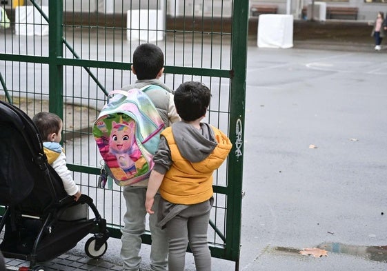 Tres niños aguardan a la entrada de una haurreskola en Gipuzkoa.