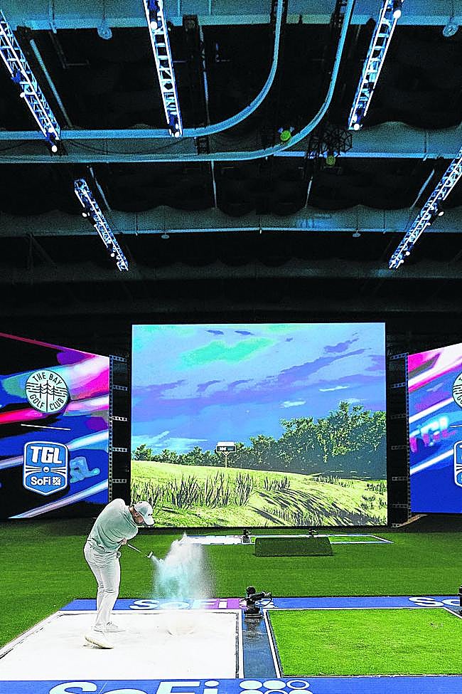 Un jugador saca de bunker. A su lado, la plataforma de hierba desde la que se realizarán los primeros golpes antes de pasar a la zona del green para terminar de embocar.