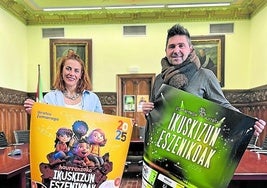 Maialen Fidalgo y Mikel Serrano con las carteleras para niños y adultos.