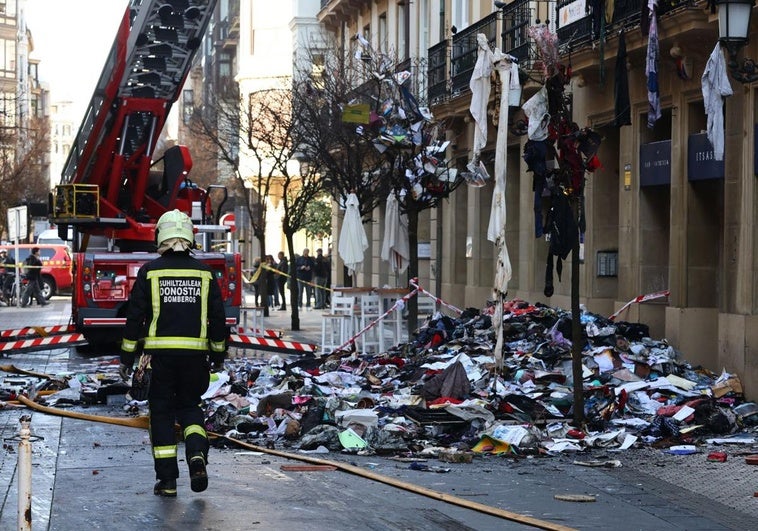 Los servicios de bomberos de Donostia trabajan en las labores de limpieza del piso incendiado.