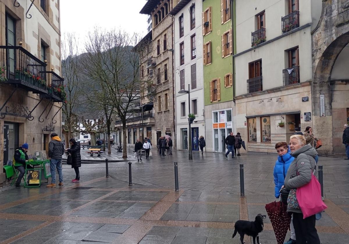 Varias personas transitan por las inmediaciones del Portalón en la lluviosa mañana de este viernes.