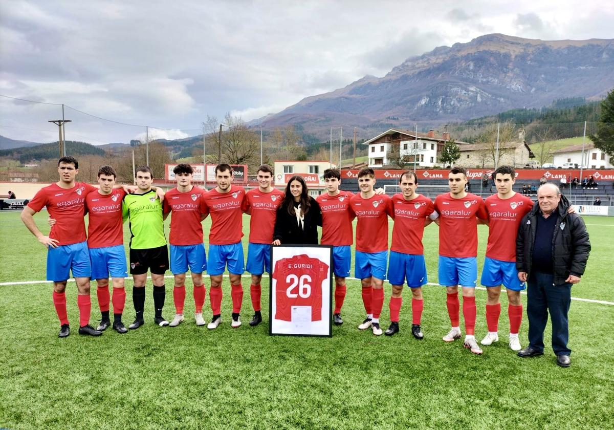 Elene Guridi Mesonero posa con el cuadro que recibió como regalo, junto al once que alineó Urzelai para enfrentarse al líder y el presidente Jabi Azpiazu.