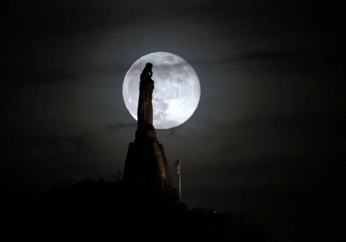 La luna llena detrás del monumento al Sagrado Corazón en San Sebastián.