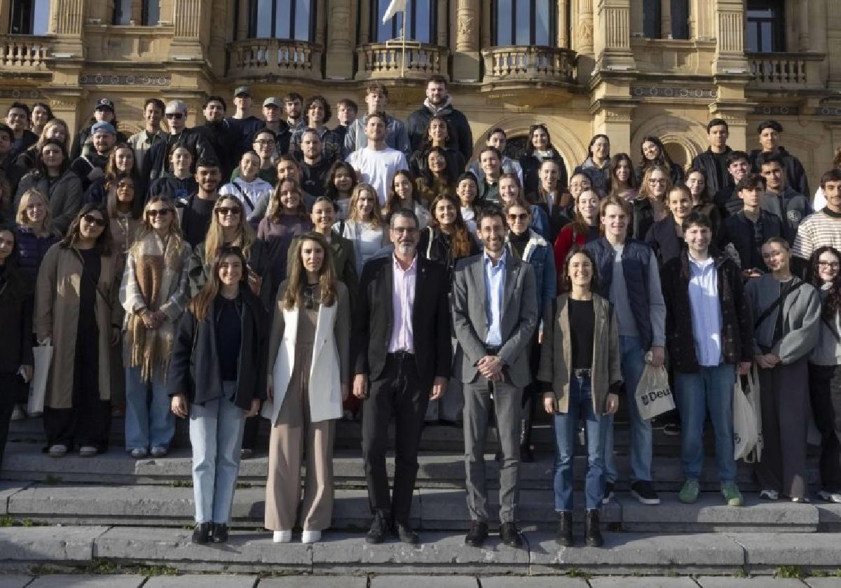 Los estudiantes internacionales posan en las escaleras que dan acceso al Ayuntamiento, con el alcalde Eneko Goia y el vicerrector del campus de Donostia de Deusto, Xabier Riezu.