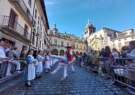 Los dantzaris en el interior de Gudarien plaza, con el Ayuntamiento y la parroquia San Juan Bautista al fondo