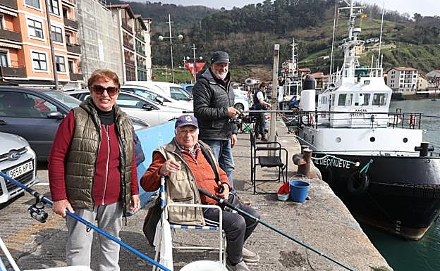 Mari Luis García, Jesús Olmos e Iñaki Esteban pescando en la zona del muelle de San Pedro junto a la lonja.