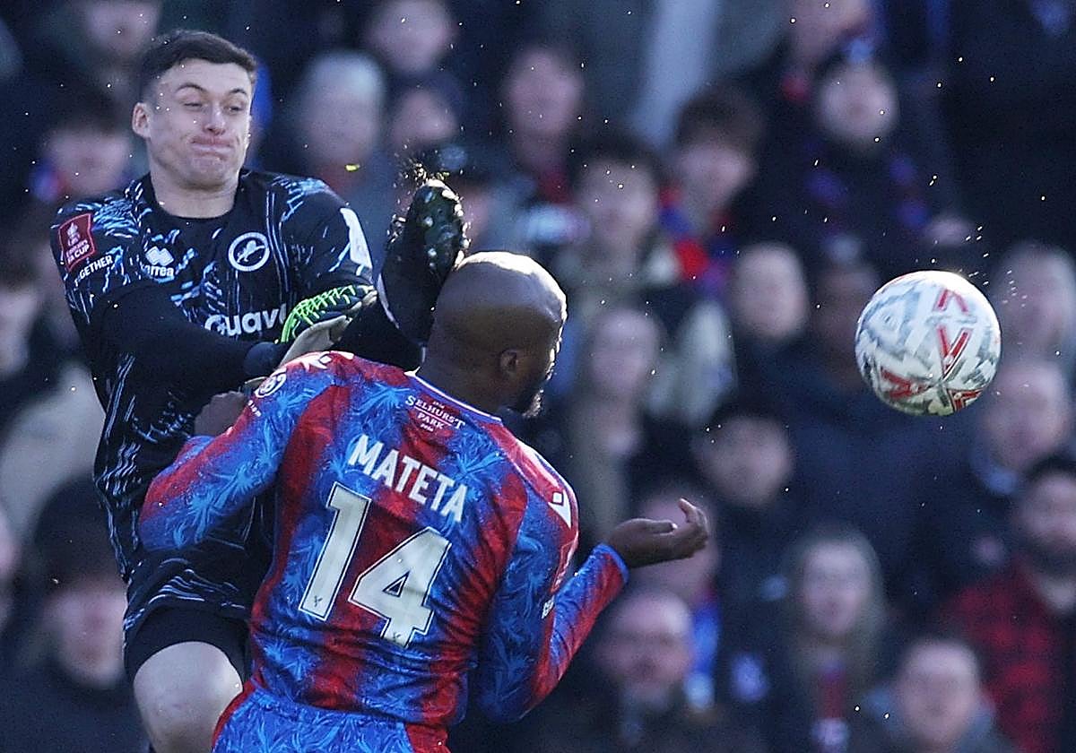El portero del Millwall Liam Roberts golpea con los tacos de su bota la cabeza de Mateta.