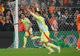 Zubimendi levanta los brazos mientras su excompañero Merino celebra el 2-2 al fondo ayer en el estadio De Kuip de Róterdam.