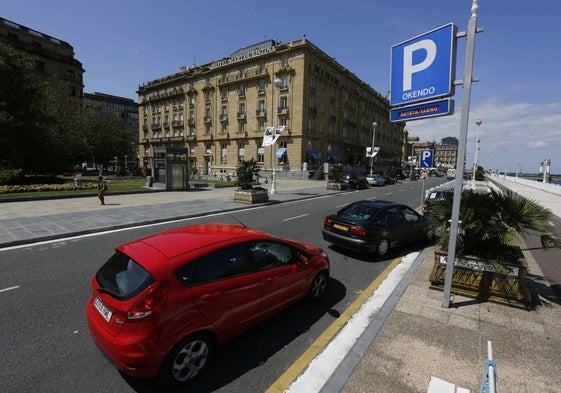 Varios coches guardan cola en el acceso al parking de Okendo, que muestra el cartel de completo.