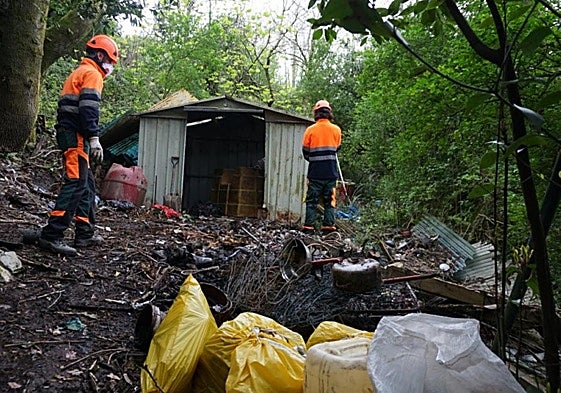 Operarios de Urzain Taldea retirando residuos acumulados en esta zona forestal pública.