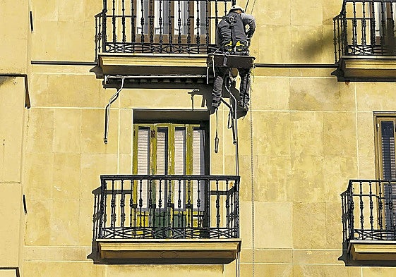 Un operario acomete labores de mantenimiento en una fachada de un edificio de Donostia