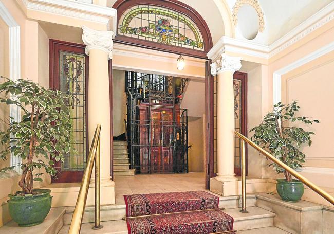 Un portal con vidrieras y ascensor antiguo ubicado en el barrio donostiarra de Gros.