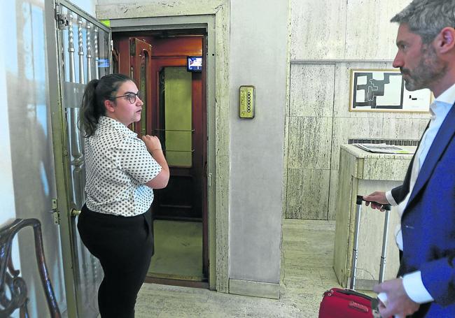 Una de las recepcionistas del Hotel Niza de Donostia explicándole a uno de los clientes el funcionamiento del ascensor.