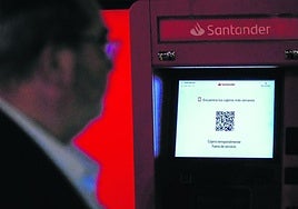 Una persona camina el lunes por delante de un cajero de un banco, que estaba temporalmente fuera de servicio.