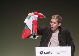 El secretario general de Sortu, Arkaitz Rodriguez, con la ikurriña en la mano.