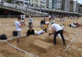 Un grupo de participantes elabora una figura de arena.