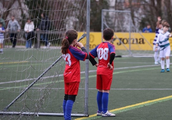 Niños y niñas juegan a fútbol en una actividad de deporte escolar organizada en un recinto donostiarra.