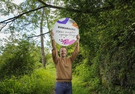 Jon Kobeaga, coordinador de Taupa, sostiene una chapa gigante con el lema del Euskaraldia.