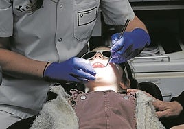 Un dentista revisa la boca de una niña durante la revisión del PADI en el ambulatorio de Iztieta, en Errenteria.