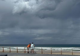 Una pareja observa el cielo y el mar ayer en el Paseo de Zurriola, en San Sebastián.