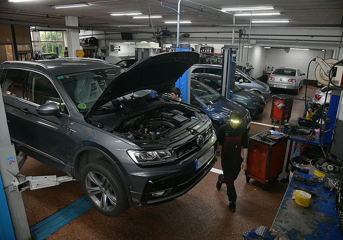 Varios mecánicos de Ayerdi Motor, en Lezo, trabajan en la reparación diferentes vehículos.