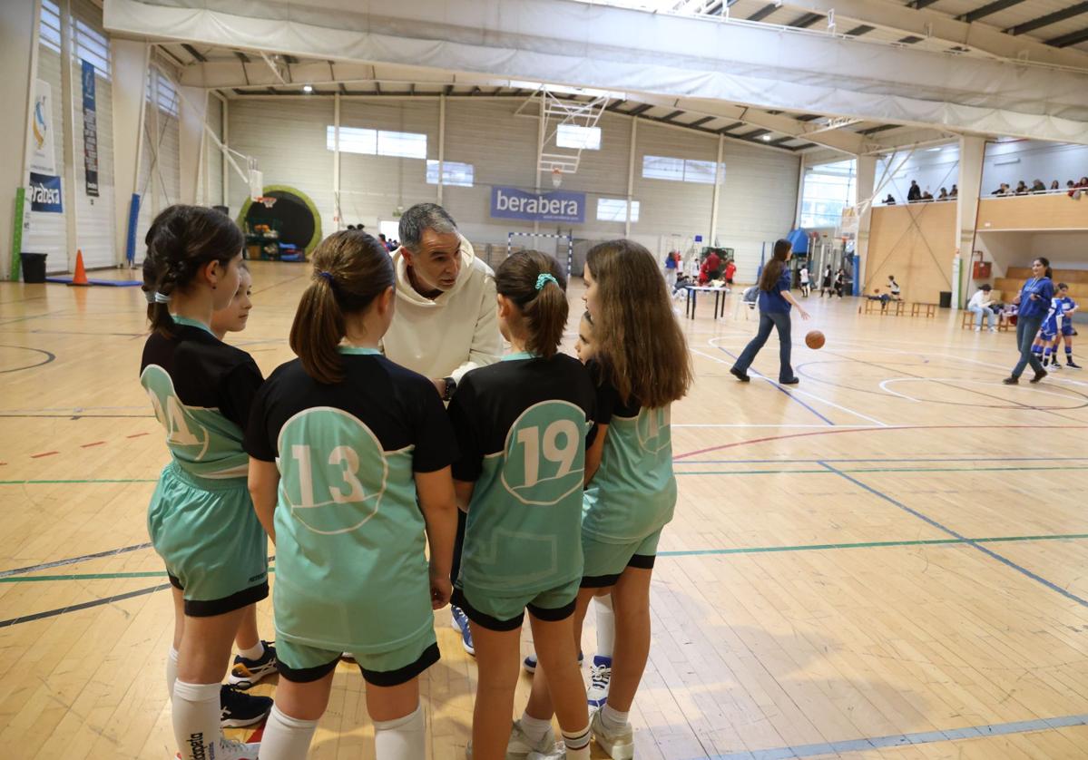 Un entrenador sin relación con la información alecciona a sus jugadoras en un partido de deporte escolar en un polideportivo de Donostia.