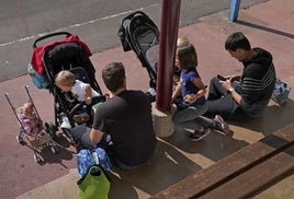 Un par de hombres cuidan de sus hijos, una imagen más habitual hoy en día que en generaciones anteriores.