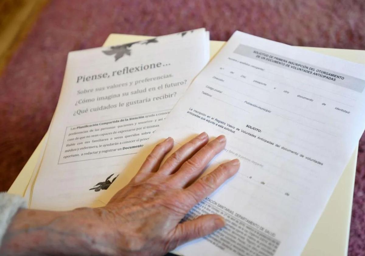 Una persona mayor sujeta documentos de voluntades no deseadas.