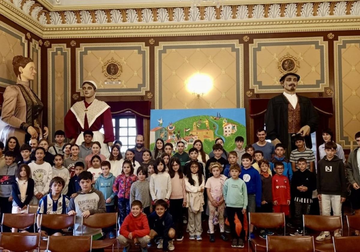 Escolares tras el encuentro junto a los gigantes que esperan a lanzar el txupinazo el 6 de junio.